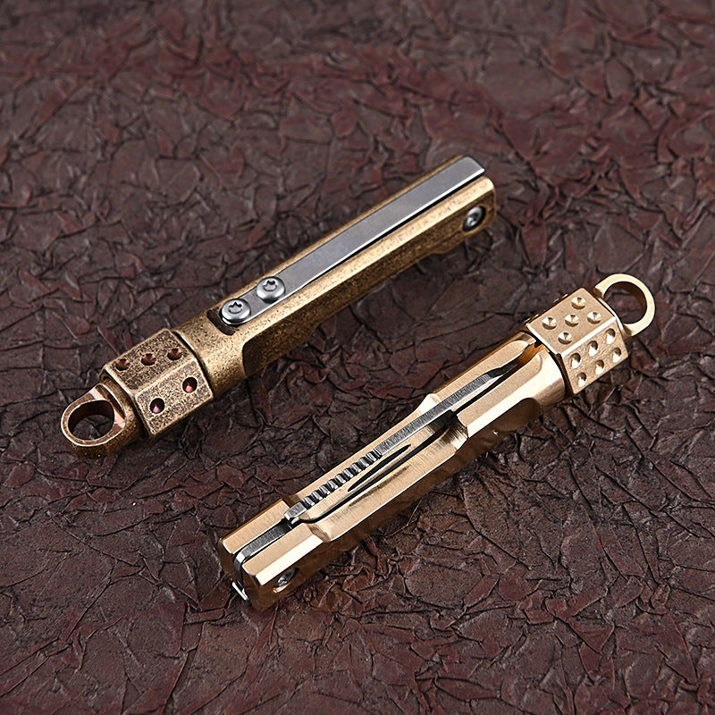 MASALONG MA-TY-041 Cuchillo plegable giratorio de latón con forma de dado, juguete de descompresión afilado, portátil, sin embalaje, caja abierta, mini cuchillo, llavero colgante
