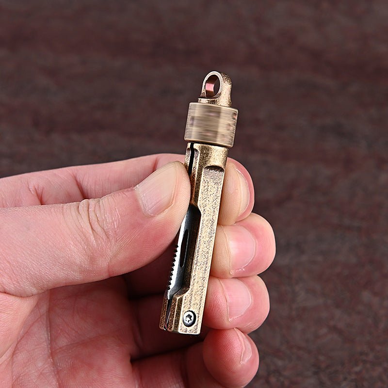 MASALONG MA-TY-041 Cuchillo plegable giratorio de latón con forma de dado, juguete de descompresión afilado, portátil, sin embalaje, caja abierta, mini cuchillo, llavero colgante